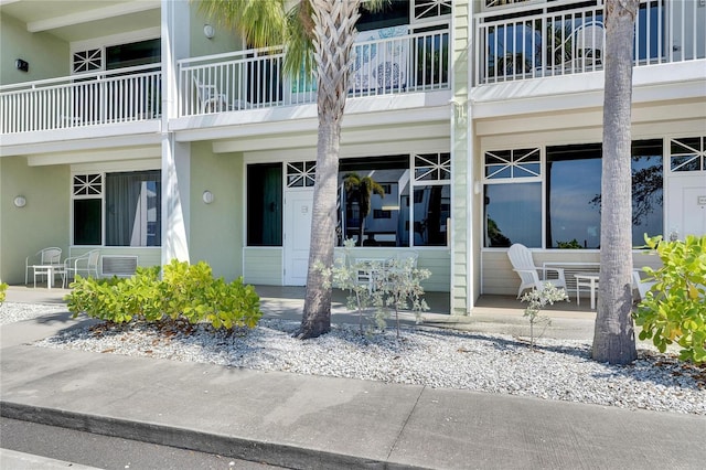 view of exterior entry with a porch and stucco siding