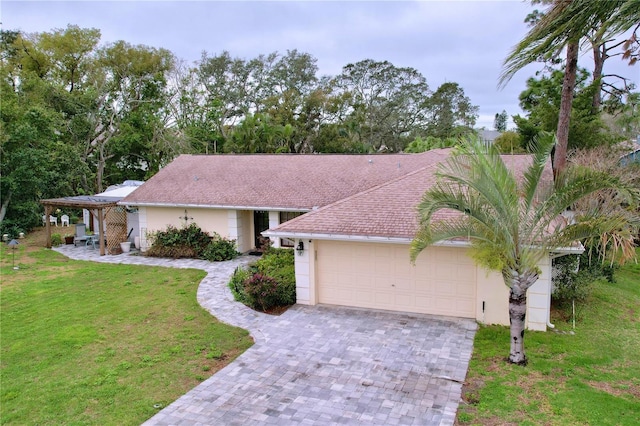 ranch-style home featuring a garage, roof with shingles, decorative driveway, a front yard, and stucco siding