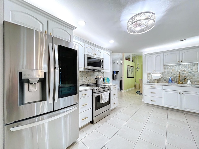 kitchen featuring tasteful backsplash, recessed lighting, appliances with stainless steel finishes, light tile patterned flooring, and a sink