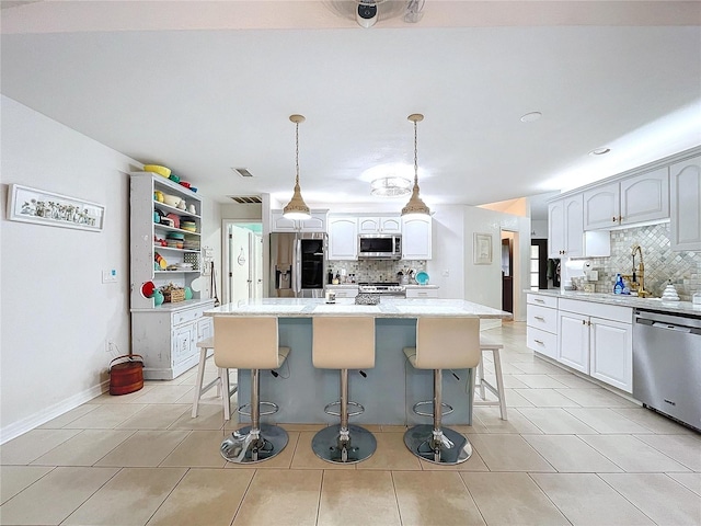 kitchen featuring stainless steel appliances, a breakfast bar area, a sink, and a center island