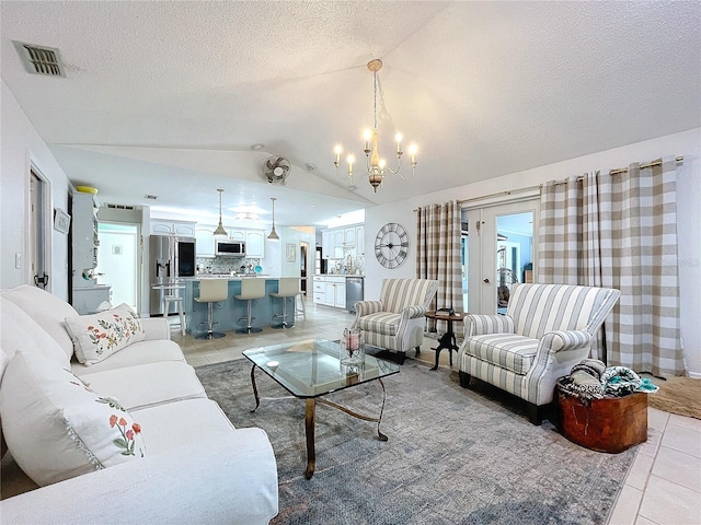 living area with light tile patterned floors, visible vents, vaulted ceiling, a textured ceiling, and a notable chandelier