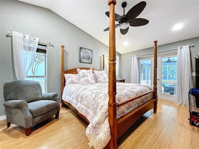 bedroom with access to exterior, light wood-style floors, multiple windows, and vaulted ceiling