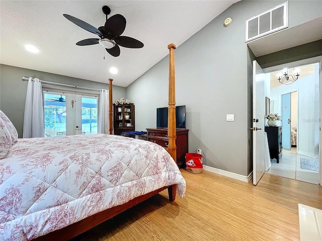 bedroom with baseboards, visible vents, lofted ceiling, wood finished floors, and access to outside