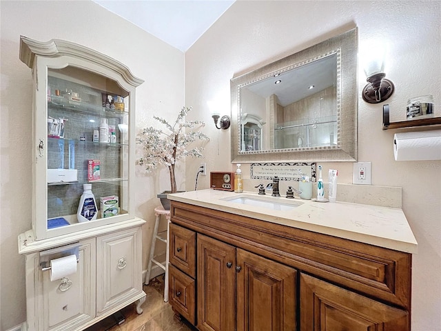 bathroom with an enclosed shower, vaulted ceiling, and vanity