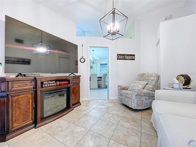 kitchen featuring baseboards, open floor plan, a chandelier, pendant lighting, and light tile patterned flooring