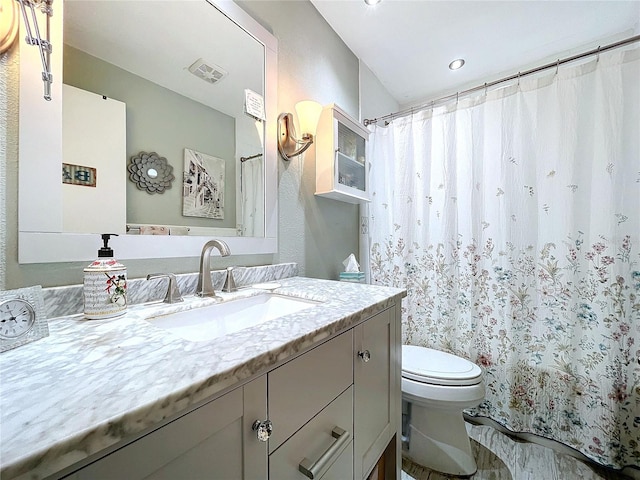 full bathroom featuring a shower with curtain, visible vents, vanity, and toilet