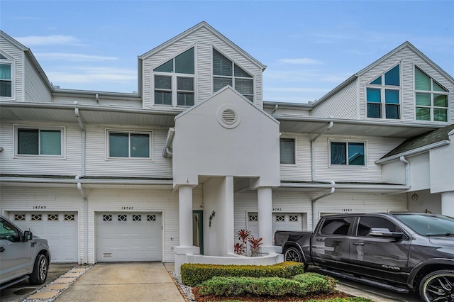 multi unit property featuring a garage and driveway