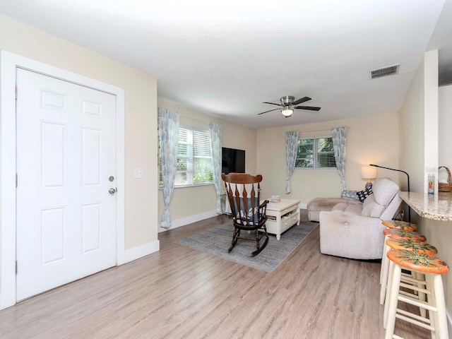 living room with a healthy amount of sunlight, light wood finished floors, and visible vents