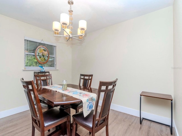 dining room with light wood-style flooring, baseboards, and a chandelier