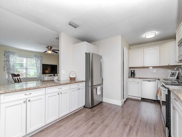 kitchen featuring tasteful backsplash, visible vents, white cabinets, light wood-style flooring, and stainless steel appliances