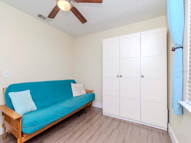 living area with a ceiling fan, visible vents, light wood-style flooring, and baseboards