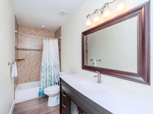 bathroom featuring shower / bath combination with curtain, visible vents, toilet, vanity, and wood finished floors