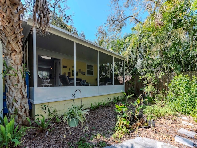 exterior space with fence and a sunroom