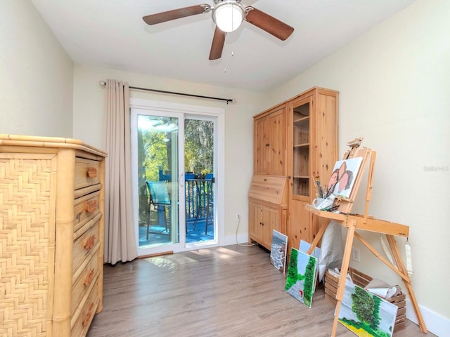 interior space featuring a ceiling fan, light wood-type flooring, and baseboards