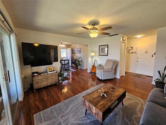 living room featuring a ceiling fan, a textured ceiling, and wood finished floors