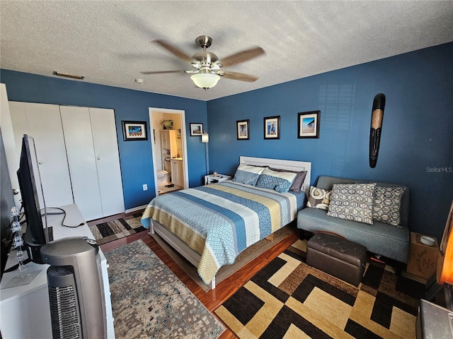 bedroom featuring a textured ceiling, wood finished floors, visible vents, a ceiling fan, and a closet