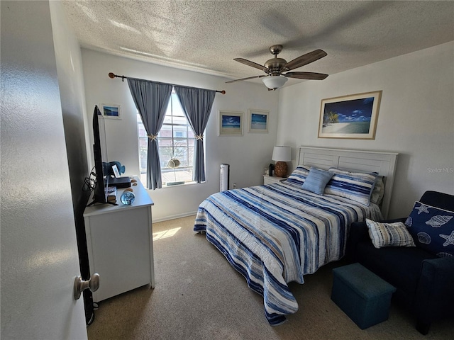 carpeted bedroom with a textured ceiling, a ceiling fan, and baseboards