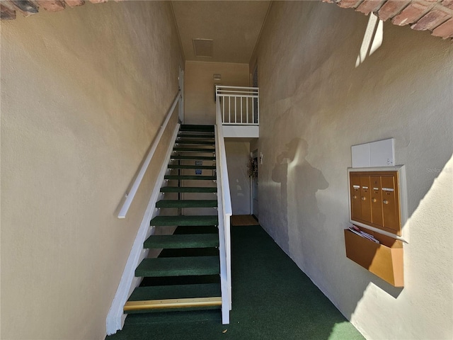 staircase with mail area and a high ceiling