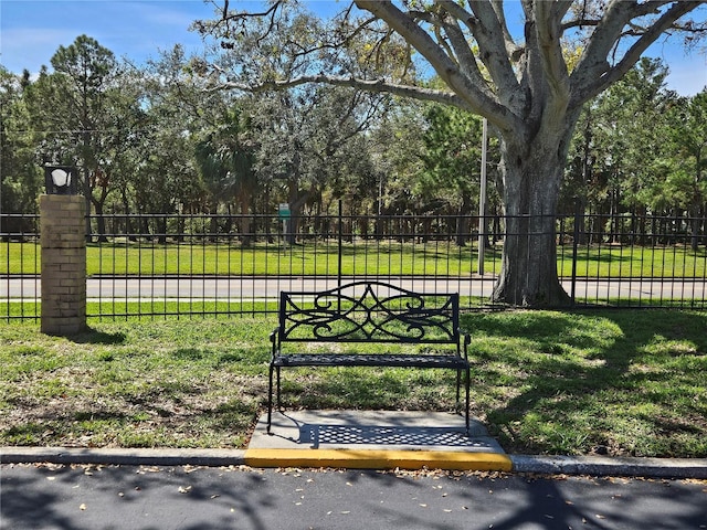 view of gate with a yard and fence