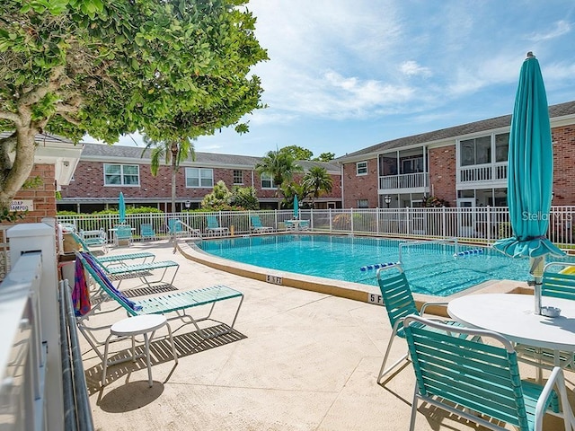 community pool featuring fence and a patio