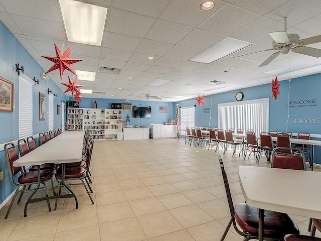 dining room featuring a paneled ceiling, tile patterned flooring, visible vents, and a ceiling fan