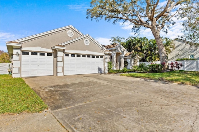 single story home featuring stucco siding, an attached garage, fence, driveway, and a front lawn