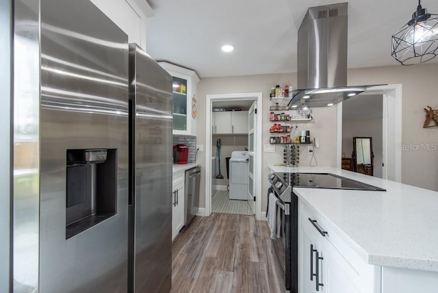 kitchen featuring stainless steel appliances, white cabinetry, light wood-type flooring, washer / clothes dryer, and island exhaust hood