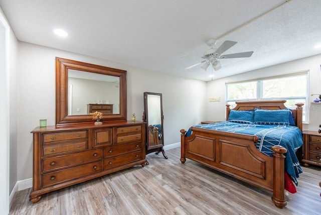 bedroom featuring light wood-style floors, baseboards, and a ceiling fan