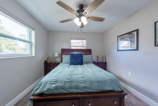 bedroom with a ceiling fan, baseboards, and wood finished floors