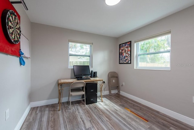 office space with baseboards, wood finished floors, and a healthy amount of sunlight