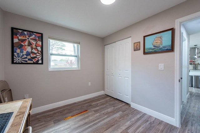 bedroom featuring a closet, baseboards, and wood finished floors