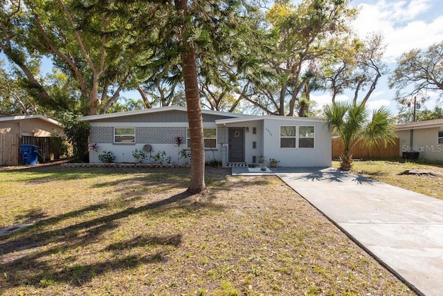 view of front of home with fence, a front lawn, and brick siding