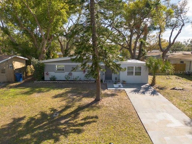 view of front facade featuring fence, concrete driveway, and a front yard