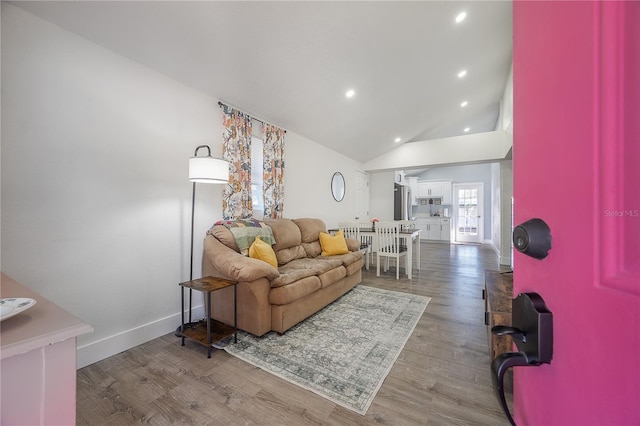 living area featuring vaulted ceiling, recessed lighting, wood finished floors, and baseboards