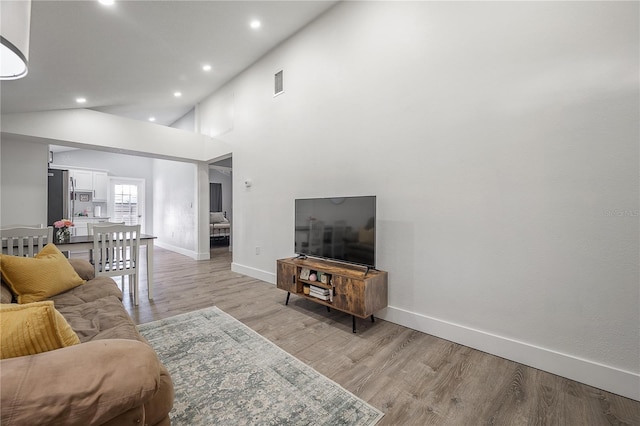 living room featuring light wood finished floors, baseboards, and visible vents