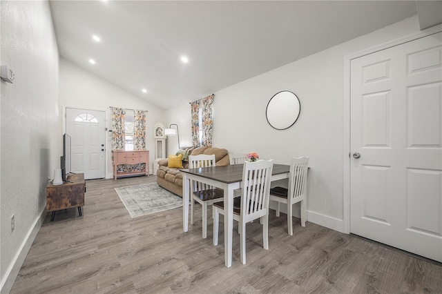 dining space with high vaulted ceiling, recessed lighting, baseboards, and wood finished floors