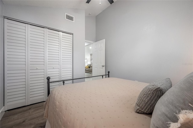 bedroom with visible vents, a ceiling fan, wood finished floors, high vaulted ceiling, and a closet