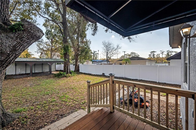 wooden terrace with a fenced backyard