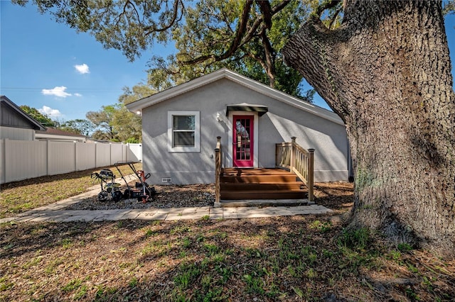 bungalow-style house with crawl space, fence, and stucco siding