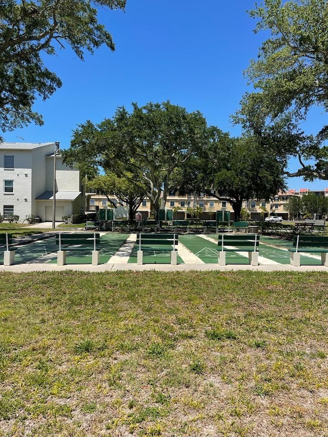 view of community featuring a lawn and shuffleboard