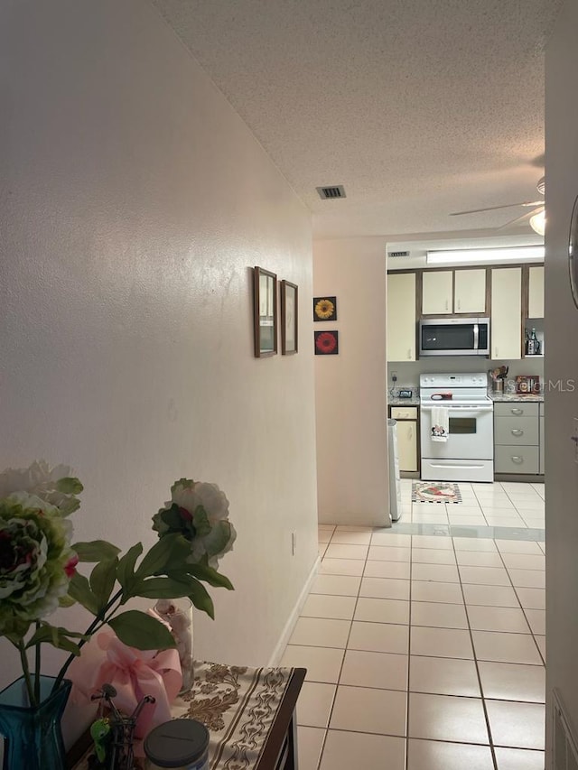 2700 Bayshore Blvd Unit 2308, Dunedin, FL 34698 - corridor featuring a textured ceiling and light tile patterned floors