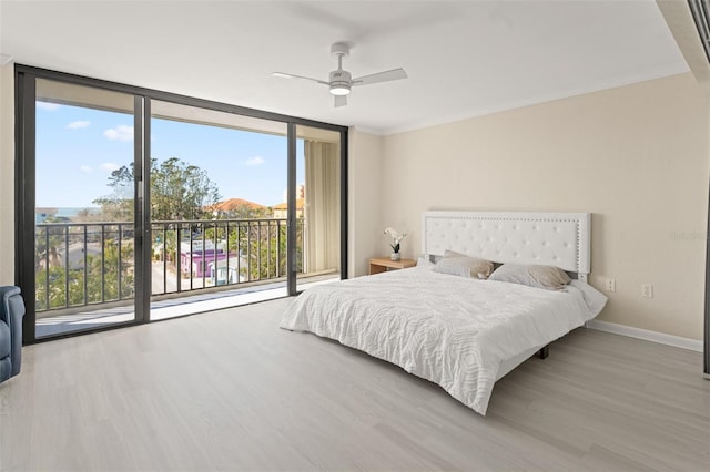 bedroom with access to outside, a wall of windows, and wood finished floors