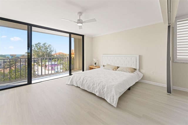 bedroom featuring expansive windows, ceiling fan, baseboards, and wood finished floors