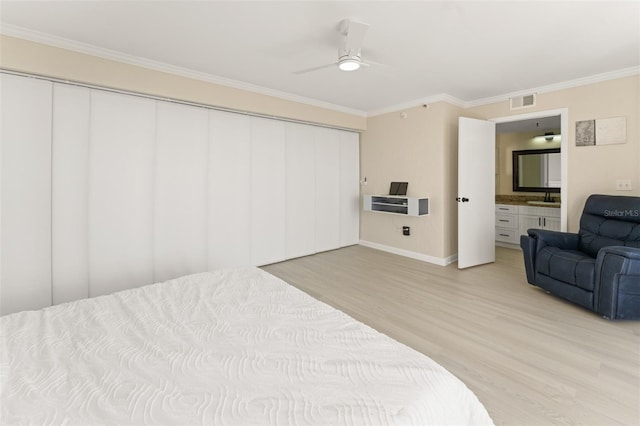 bedroom with light wood-style flooring, a sink, visible vents, ornamental molding, and a closet