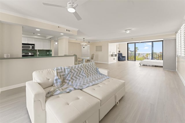 living area with light wood finished floors, visible vents, ornamental molding, and baseboards