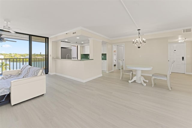 living room with visible vents, baseboards, ornamental molding, light wood-type flooring, and ceiling fan with notable chandelier