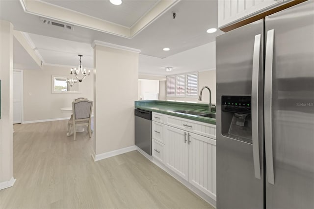 kitchen featuring light wood finished floors, visible vents, appliances with stainless steel finishes, ornamental molding, and a sink