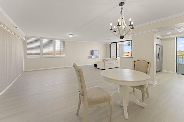 dining area featuring light wood-type flooring, baseboards, ornamental molding, and a chandelier