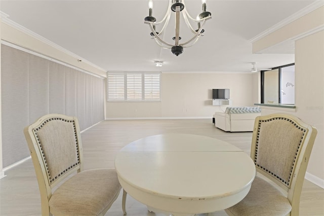 dining room featuring baseboards, ornamental molding, light wood-style flooring, and a notable chandelier