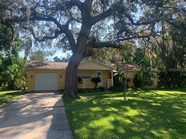 ranch-style home with a garage, a front yard, and driveway